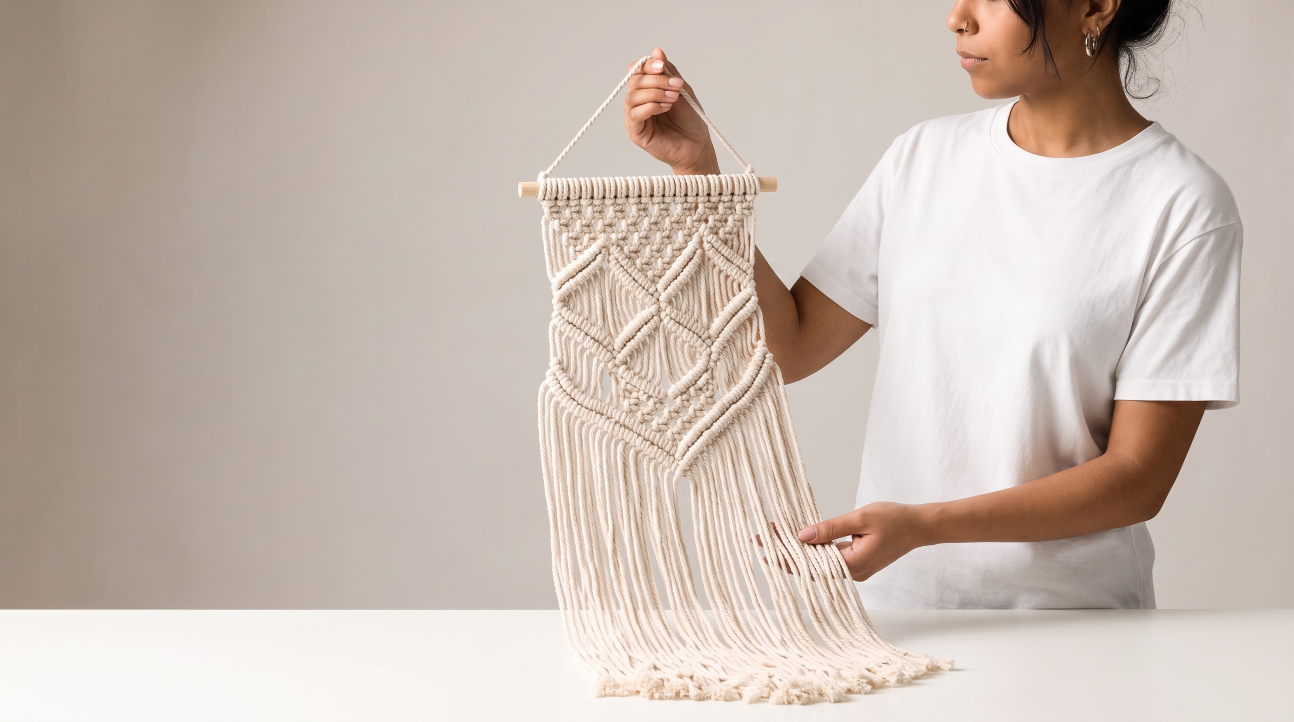 Bohemian hand-knotted macrame wall art held by a person indoors